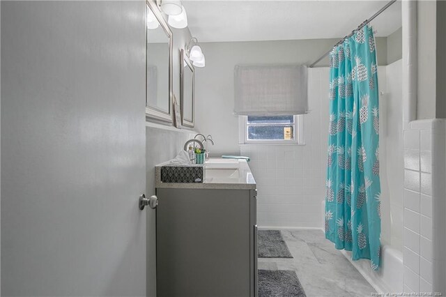 bathroom with vanity, shower / bathtub combination with curtain, and tile walls