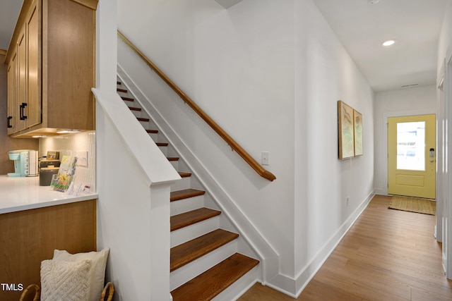 stairs featuring hardwood / wood-style flooring