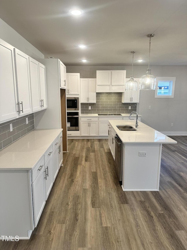 kitchen featuring stainless steel appliances, white cabinetry, hanging light fixtures, and sink