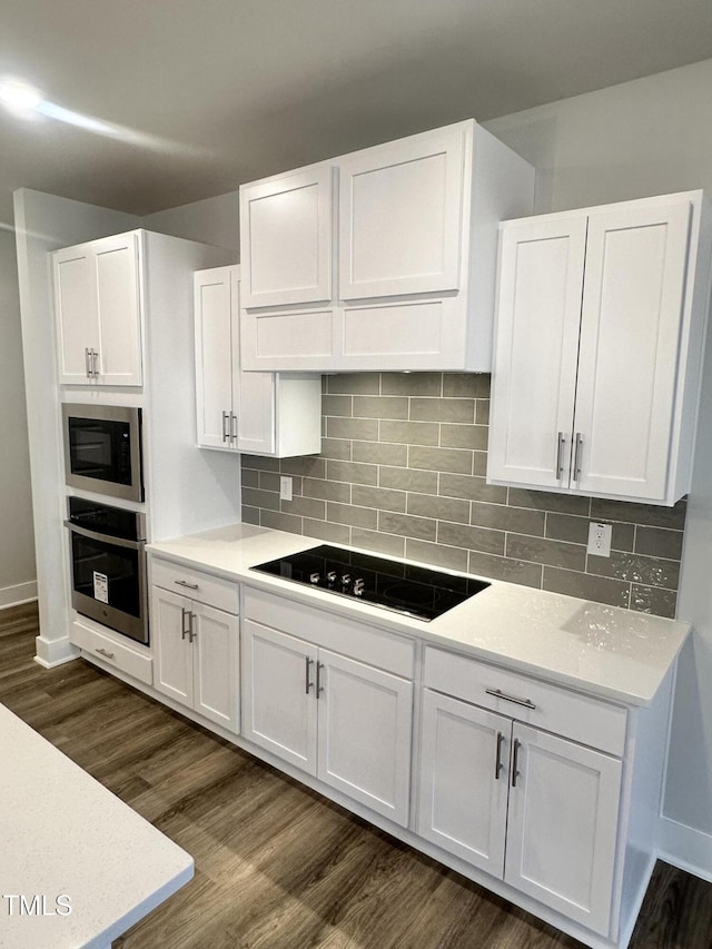 kitchen with dark hardwood / wood-style floors, white cabinets, backsplash, and black appliances