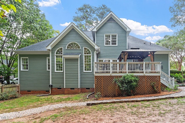 rear view of house featuring a gazebo and a deck