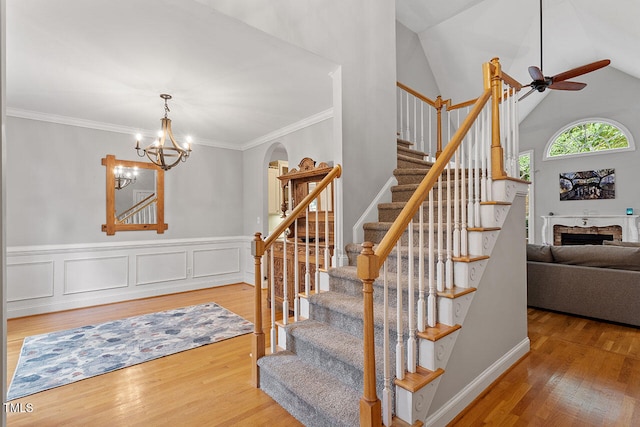 stairway featuring hardwood / wood-style flooring, a chandelier, crown molding, and vaulted ceiling