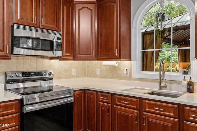 kitchen featuring sink, stainless steel appliances, and tasteful backsplash