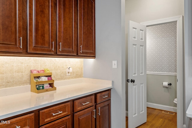 interior space with tasteful backsplash and light wood-type flooring