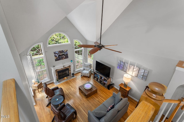 living room featuring hardwood / wood-style floors, high vaulted ceiling, and ceiling fan