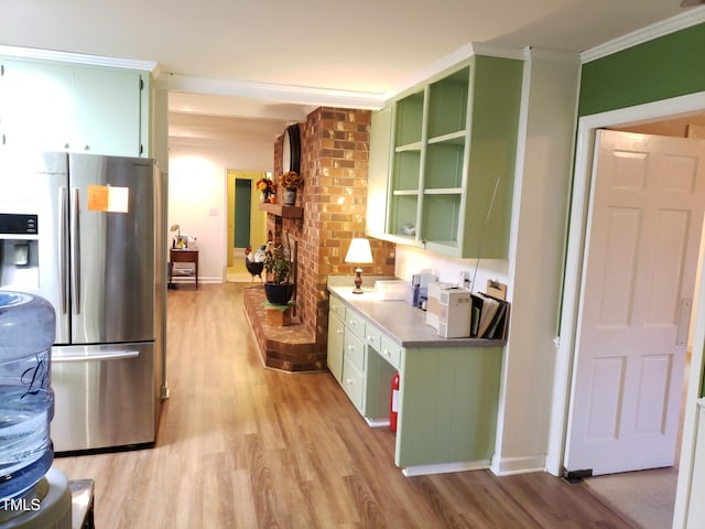203 Green St, Fremont, NC 27830 - kitchen with green cabinets, freestanding refrigerator, light wood-type flooring, crown molding, and baseboards