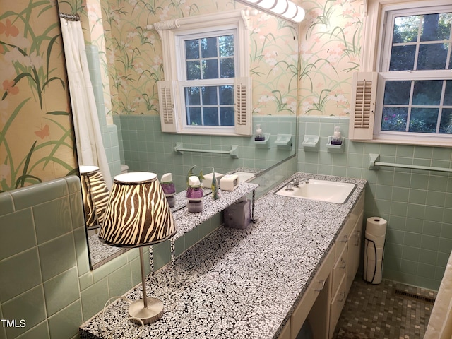 bathroom with vanity and tile walls