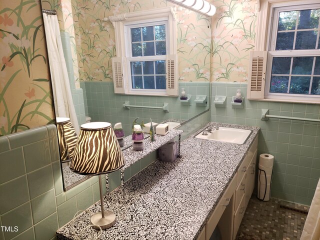 203 Green St, Fremont, NC 27830 - bathroom with wallpapered walls, tile walls, vanity, wainscoting, and tile patterned flooring