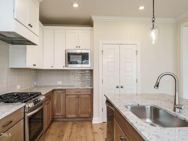 kitchen featuring sink, stainless steel appliances, light hardwood / wood-style flooring, white cabinets, and ornamental molding