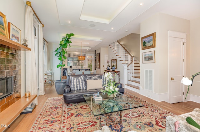 living room featuring a tile fireplace and light hardwood / wood-style floors