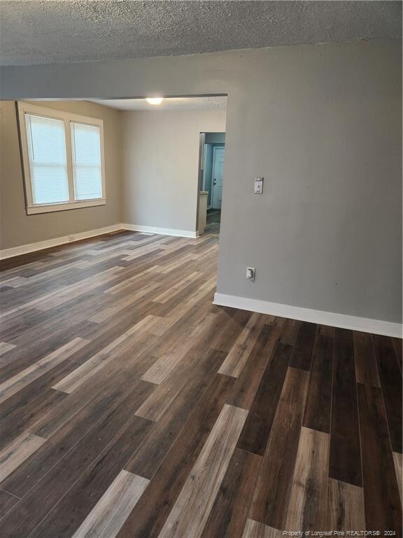 110 N Grove Ave, Rockingham, NC 28379 - unfurnished room featuring baseboards, wood finished floors, and a textured ceiling