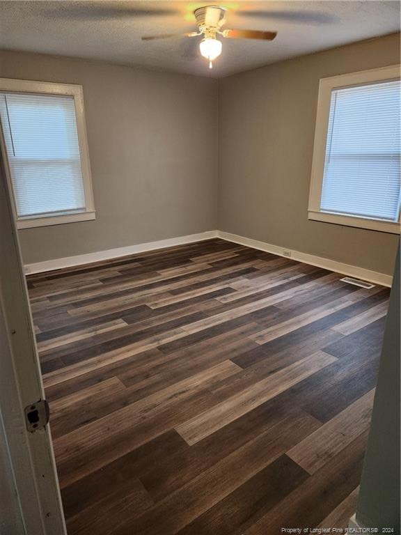 110 N Grove Ave, Rockingham, NC 28379 - empty room with dark wood-type flooring, ceiling fan, and baseboards