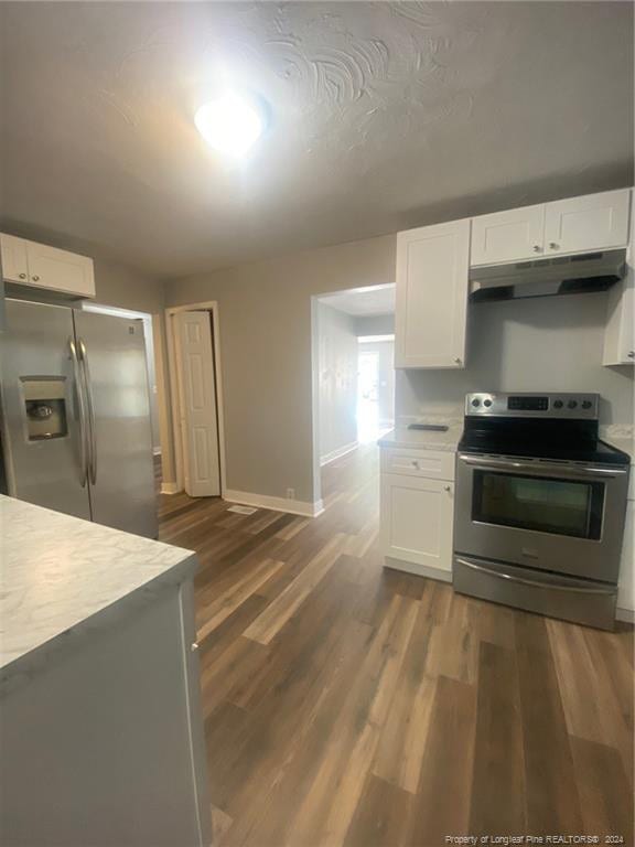 110 N Grove Ave, Rockingham, NC 28379 - kitchen with appliances with stainless steel finishes, under cabinet range hood, light countertops, baseboards, and white cabinetry