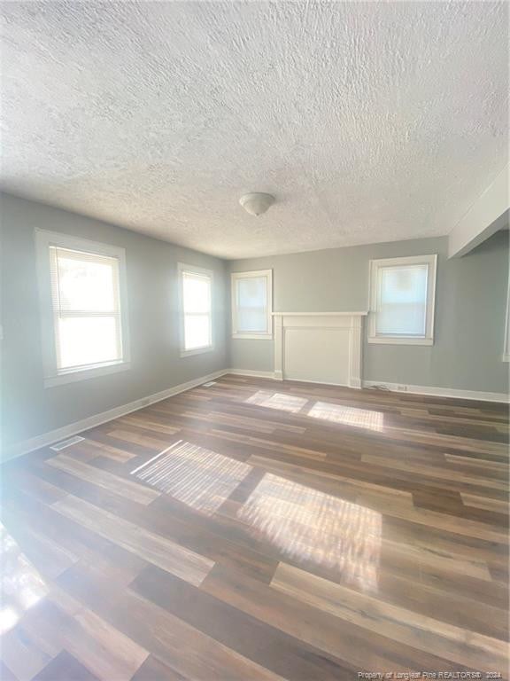 110 N Grove Ave, Rockingham, NC 28379 - spare room featuring a textured ceiling, wood finished floors, and baseboards