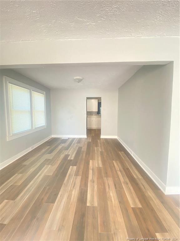 110 N Grove Ave, Rockingham, NC 28379 - empty room featuring wood finished floors, baseboards, and a textured ceiling