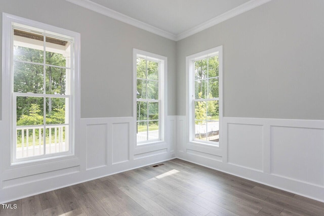 doorway to outside with a wainscoted wall, ornamental molding, and dark wood finished floors