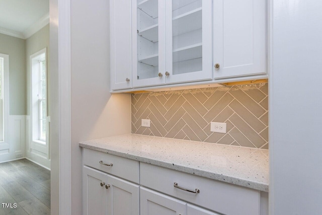 bar featuring tasteful backsplash, crown molding, and wood finished floors