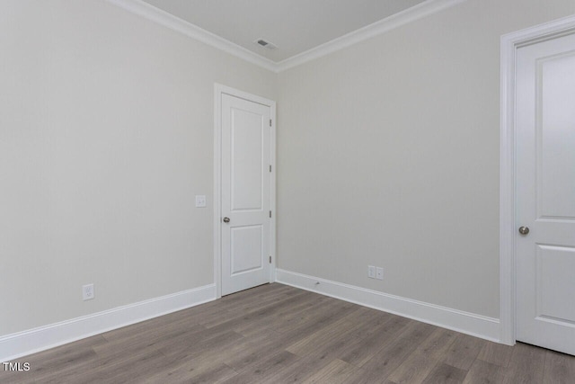 unfurnished room with ornamental molding, wood finished floors, visible vents, and baseboards