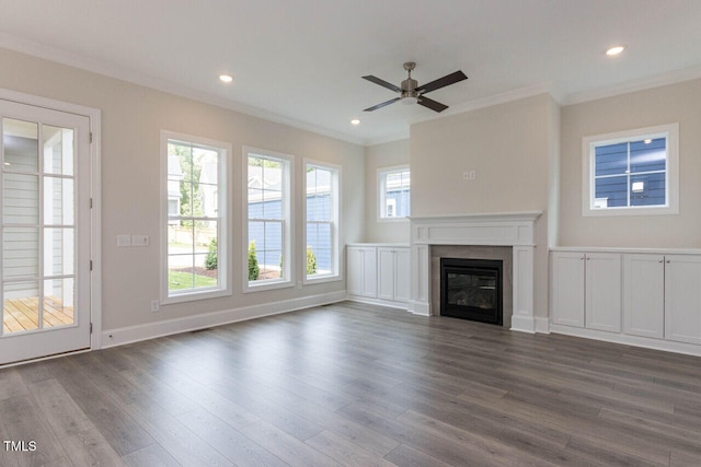 unfurnished living room with ornamental molding, dark wood finished floors, a glass covered fireplace, and recessed lighting