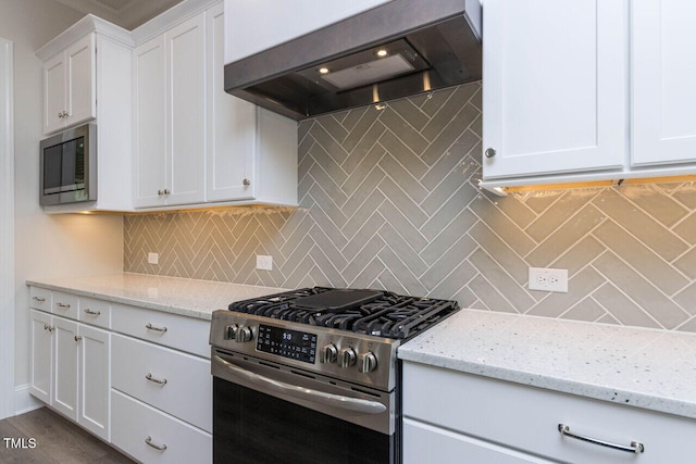 kitchen featuring white cabinets, premium range hood, stainless steel appliances, and decorative backsplash