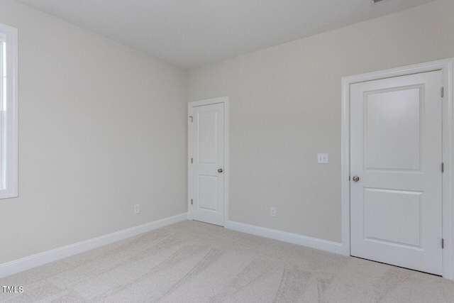 carpeted empty room with baseboards