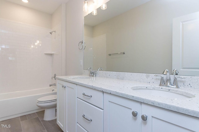 full bathroom with double vanity,  shower combination, a sink, and toilet