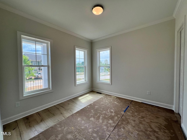 6044 Scalybark Rd, Durham, NC 27712 - spare room with healthy amount of natural light, crown molding, baseboards, and wood finished floors