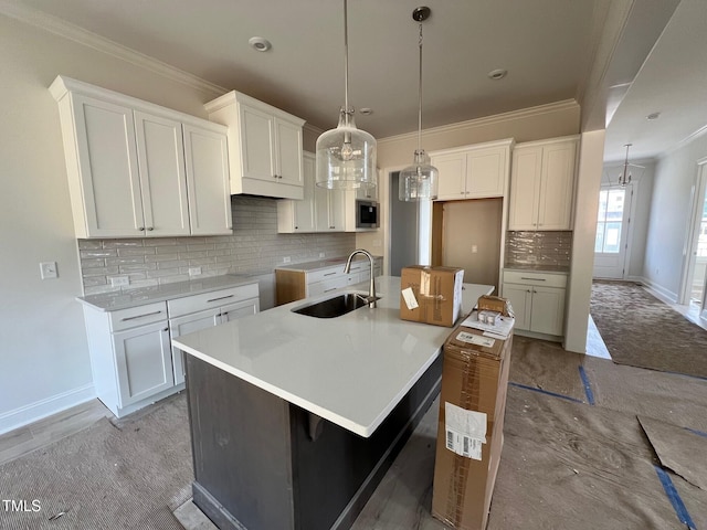 6044 Scalybark Rd, Durham, NC 27712 - kitchen featuring a sink, stainless steel microwave, a large island with sink, backsplash, and baseboards