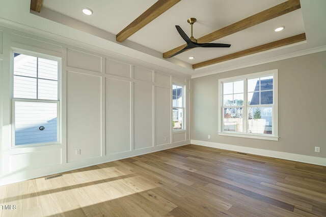 unfurnished room with a raised ceiling, ceiling fan, crown molding, beamed ceiling, and hardwood / wood-style floors