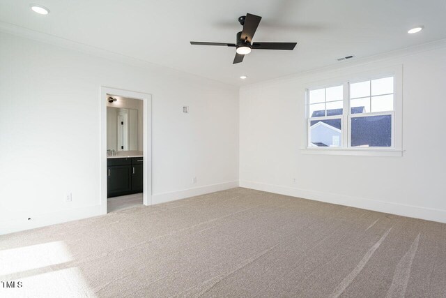 carpeted empty room with ceiling fan and ornamental molding