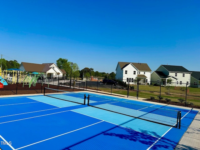 view of tennis court with a playground