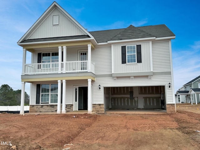 view of front facade with a garage, a balcony, and a porch