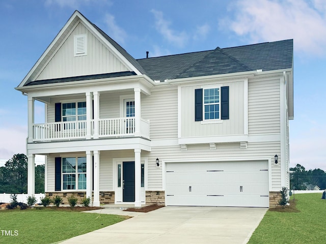 view of front of property featuring driveway, stone siding, a balcony, and a front yard