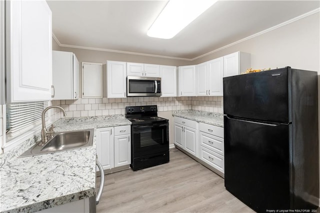 kitchen featuring sink, light hardwood / wood-style floors, white cabinetry, and black appliances