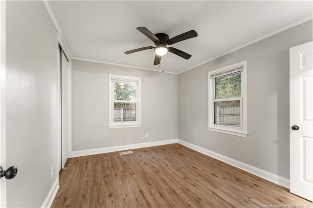 unfurnished room featuring hardwood / wood-style flooring, plenty of natural light, and crown molding