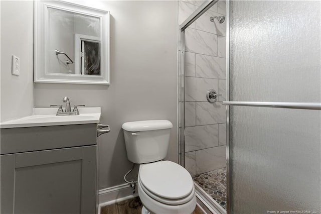 bathroom with wood-type flooring, vanity, toilet, and walk in shower