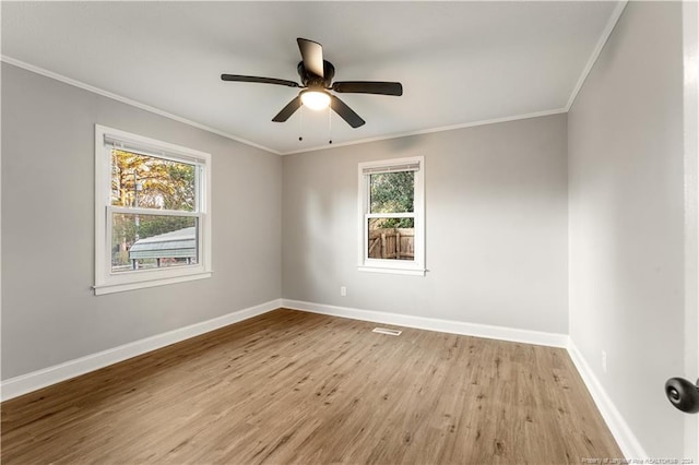 spare room with plenty of natural light, light hardwood / wood-style floors, and crown molding