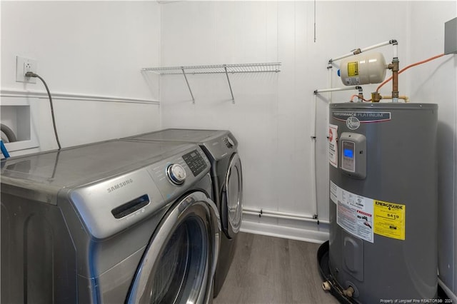 clothes washing area featuring independent washer and dryer, dark hardwood / wood-style flooring, and water heater