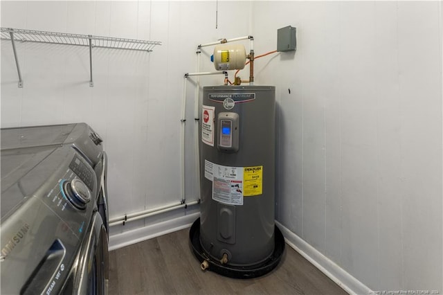 washroom featuring washing machine and dryer, electric water heater, and hardwood / wood-style flooring