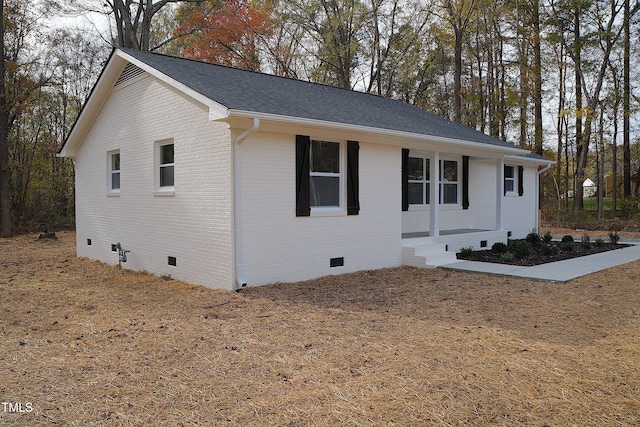 view of front of house featuring crawl space, brick siding, and roof with shingles