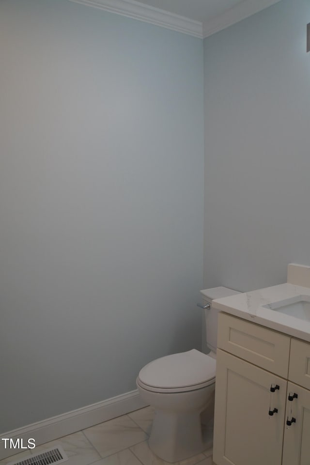 half bath with baseboards, toilet, ornamental molding, marble finish floor, and vanity