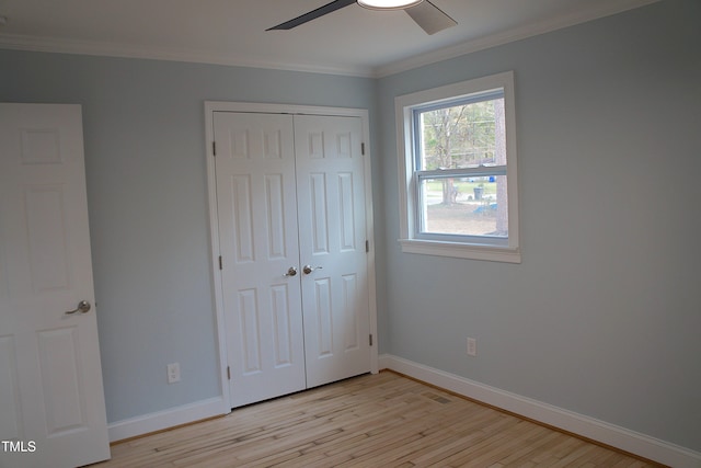 unfurnished bedroom with light wood-style floors, a closet, ornamental molding, and baseboards