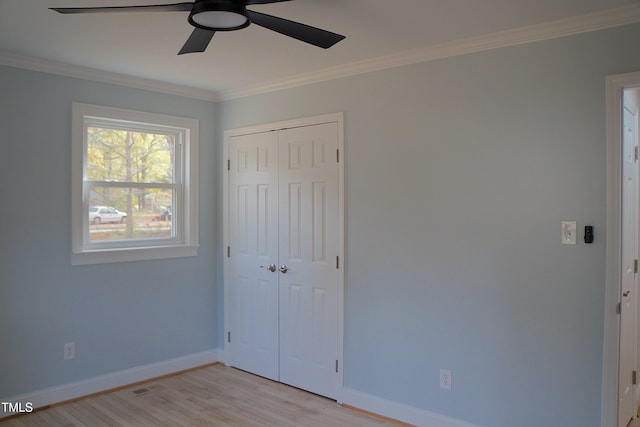 unfurnished bedroom featuring light wood-style floors, ornamental molding, and baseboards