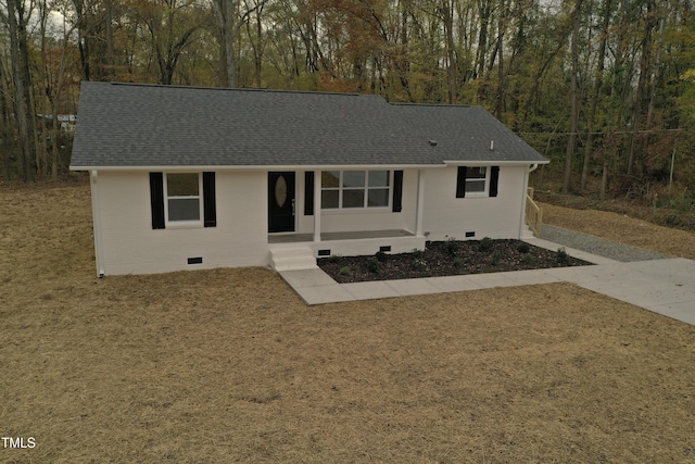 ranch-style home with crawl space, covered porch, roof with shingles, and brick siding