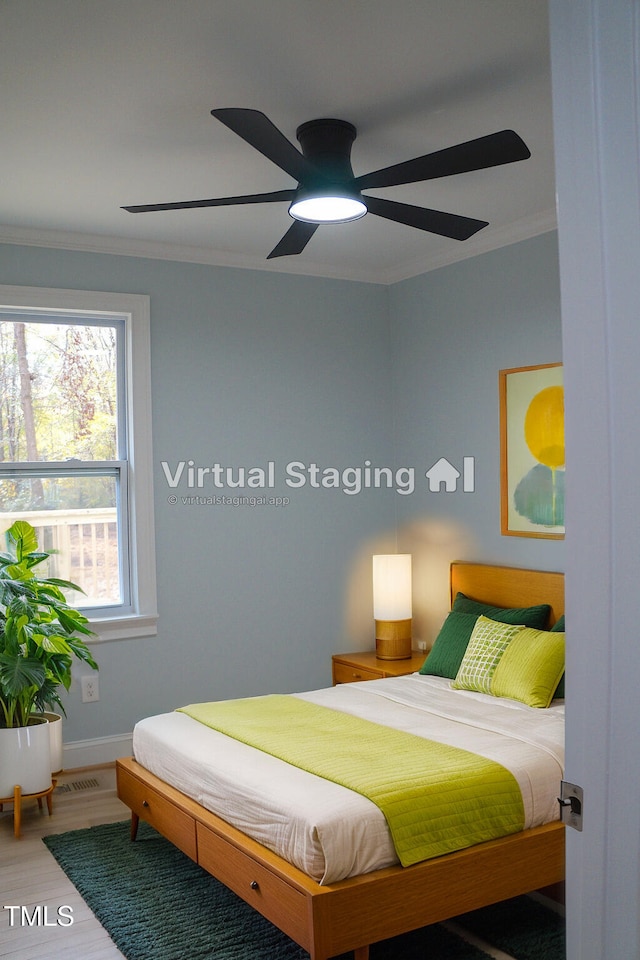 bedroom with baseboards, a ceiling fan, crown molding, and wood finished floors