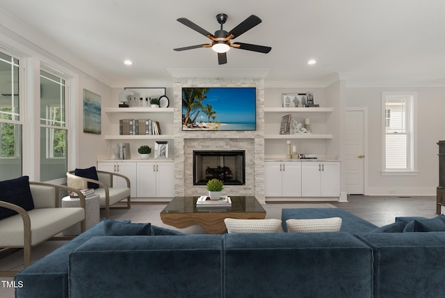 living room with a fireplace, crown molding, hardwood / wood-style floors, and ceiling fan