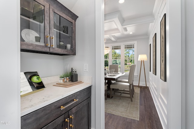 bar featuring beamed ceiling, dark brown cabinetry, dark hardwood / wood-style floors, and coffered ceiling