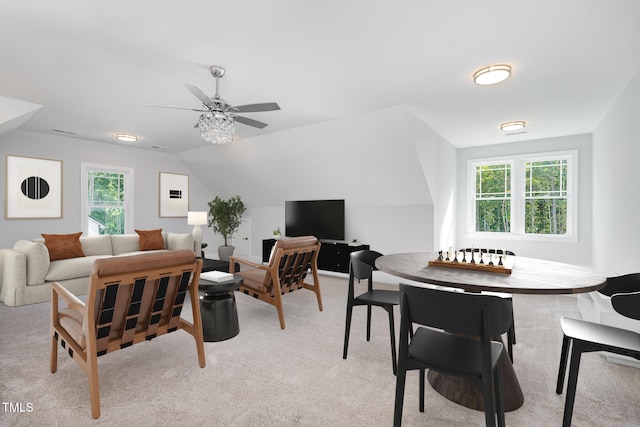 carpeted living room with ceiling fan, a wealth of natural light, and vaulted ceiling