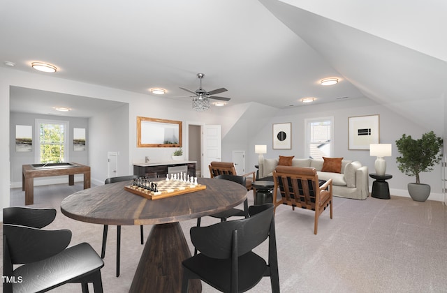 dining space featuring light carpet, plenty of natural light, ceiling fan, and vaulted ceiling