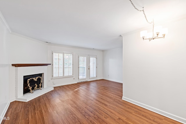 1321 Dylan Heath Ct, Raleigh, NC 27608 - unfurnished living room featuring a chandelier, ornamental molding, wood finished floors, and a brick fireplace